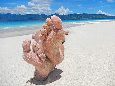 桑迪脚踏在热带海滩上天堂女性异国支撑按钮蓝色海洋情调说谎鞋底图片
