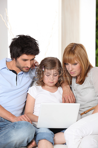 在沙发上有女儿和膝上型电脑图片