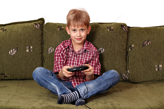 男孩坐在床上玩电子游戏图片