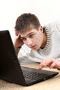 带笔记本的年轻人游戏男人沙发黑发互联网电脑说谎青年键盘工具图片