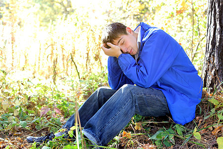 悲伤的青年男子男性焦虑寂寞森林失败紧张树木头发牛仔裤思维图片