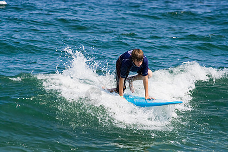 少年男孩冲浪男生竞技支撑冲浪者海滨男性木板海洋身体娱乐图片