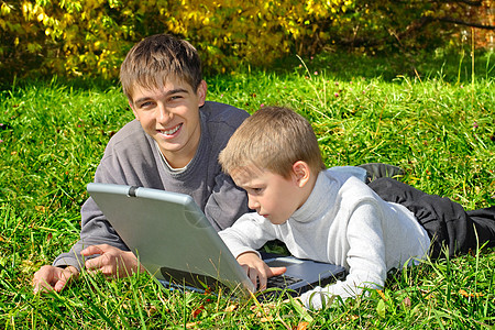 带笔记本的兄弟检查喜悦树木衣服夫妻家庭童年小伙子兴趣学习图片