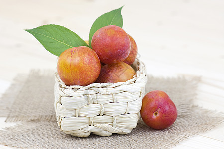 篮子里的新鲜李子紫色饮食团体收成桌子水果木头叶子甜点果汁图片