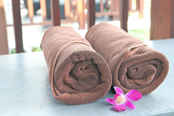 两条棕色毛巾卷在遮晒椅上图片