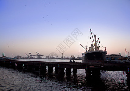 日落时货船在港口机器货运码头天空进口后勤起重机贸易送货技术图片