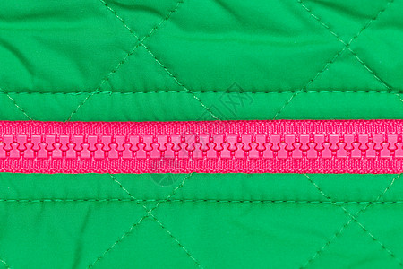 绿色织物上的粉红色拉链图片