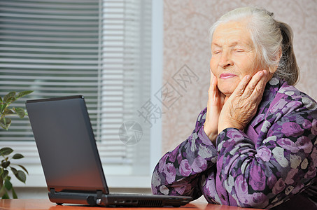 在笔记本电脑前的老年妇女女性女士白色祖母灰色成人衣服摄影微笑起皱图片