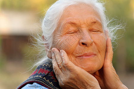 闭着眼睛的年长妇女老年人情感女性生活皱纹退休长老头发老年阳光图片