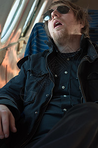 一名青年男子睡在飞机座椅上的肖像图片