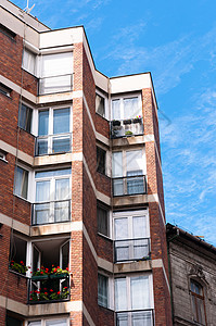 欧洲对抗蓝天通用公寓楼的蓝色平面生活障碍建筑学酒吧白色建筑房子阳台居住窗户图片