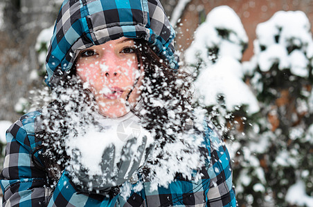 迷人的年轻女子手握雪雪降雪季节头发女性女士嘴唇衣服手套围巾乐趣图片