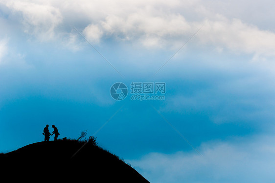 一对夫妇到达山峰顶的山峰图片