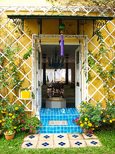 黄色房子墙 门和花敞开背景照明入口小地毯墙纸花瓶喷泉住宅木头背景图片