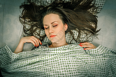 床上的年轻女人白色眼睛枕头黑色头发休息女士女孩卧室女性图片