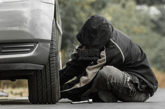 青年男子在户外修车绿色检查维修发动机车辆运输灰色夹克工作外套图片