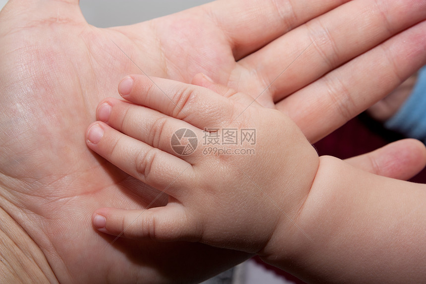 父亲和婴儿的手新生儿孩子救助新生手臂后盾白色父母手指护理图片