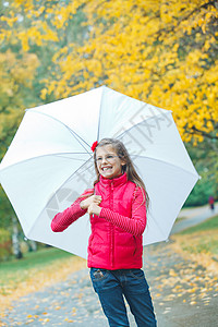 小女孩在雨中行走胡同雨衣天气森林快乐树叶女孩孩子人行道兜帽图片