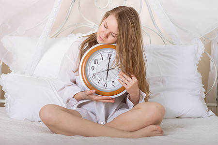 睡钟和闹钟中的年轻美女休息女孩头发睡眠时间警报苏醒青少年卧室房间图片