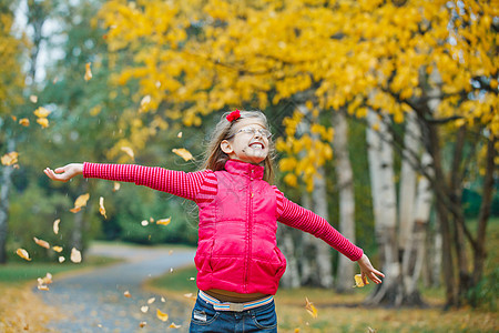 在秋天公园散步的可爱女孩青年快乐雨滴微笑森林公园人行道童年胡同雨衣图片