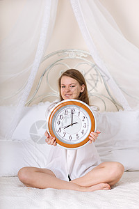 睡钟和闹钟中的年轻妇女拨号苏醒女性青少年青年休息早餐睡眠时间女孩图片