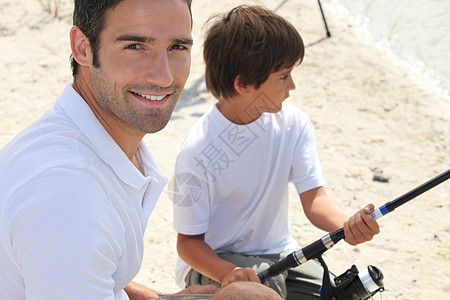 父亲和儿子在捕鱼旅行期间结交男人卷轴追求家庭孩子们假期童年快乐海岸微笑图片