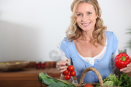 怀着胡椒和西红柿的妻子女性厨房篮子夫妻食物头发福利微笑女士幸福图片
