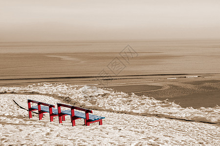 冬季海滩风景和红色长椅图片