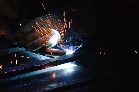 工作中的铁匠金工材料火焰零售商焊机焊接火花冲击金属图片