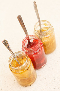 装满水果果酱的不同罐子营养覆盆子食物明胶黑色果味勺子玻璃橙子甜点图片