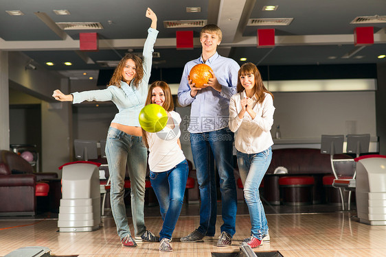 一群玩保龄球的年轻朋友娱乐女性幸福运动游戏女孩投掷胡同咖啡店欢呼图片