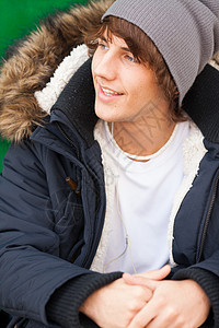 英俊的青年男子用耳机肖像男人微笑夹克公园图片