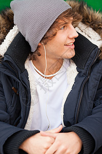 英俊的青年男子用耳机肖像公园男人微笑夹克图片