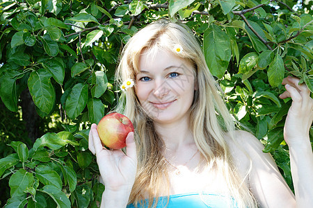 有苹果的女孩冒充花朵水果金发女郎微笑女性发型饮食头发成人图片