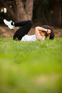 年轻美丽的拉丁女人做腹肌拉丁女孩头发跑步重量肌肉绿色公园平衡女士图片