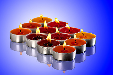 彩色蜡烛橙子辉光蓝色烛光反射红色火焰茶色背景图片