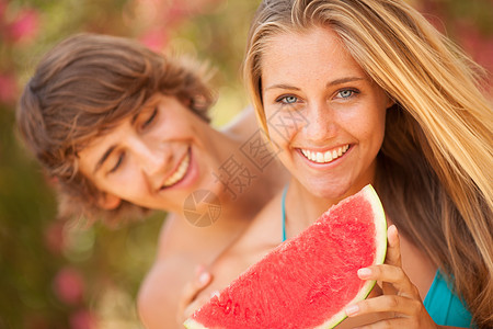 一对年轻的美美夫妇吃西瓜的肖像快乐太阳水果营养男生女孩微笑乐趣女士友谊图片