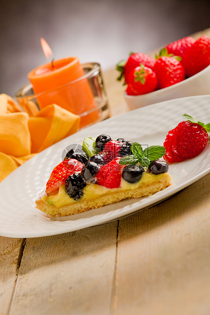 用蜡烛和草莓饼糕点食物奶油奇异果浆果桌木甜点餐巾纸水果薄荷图片