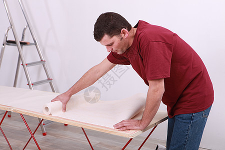 拿着一卷墙纸的人桌子男性工艺倾斜职业思考金属风格公司装潢图片
