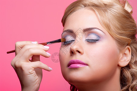 使用化妆油漆刷子的年轻妇女魅力肤色眼影眼睛女士治疗女性女郎身体金发图片