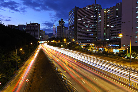 夜间在现代城市的光线小径街道景观运动速度高楼交通蓝色汽车运输中心图片