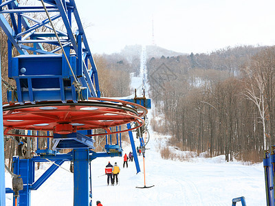 在俄罗斯普里莫尔斯基地区 滑雪者在山上搭起电梯路线假期乐趣蓝色滑雪娱乐升降椅缆车旅行回旋图片