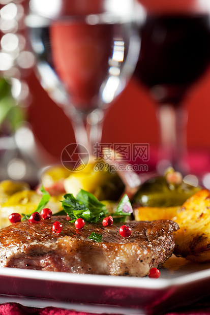 牛排加红辣椒玉米和布鲁斯芽盘子胡椒子牛肉玻璃桌子烛光用餐桌布美食蜡烛图片