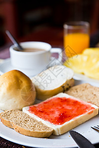 咖啡 面包和果汁 在餐桌上的盘子上图片
