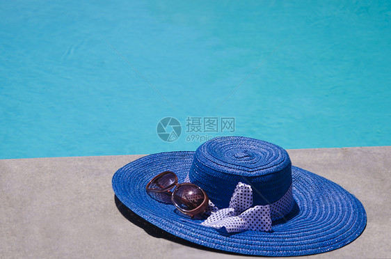 游泳池旁的女子用品假期游泳水池太阳镜酷暑图片