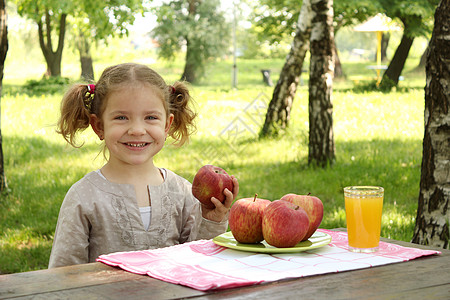 公园里有苹果和果汁的小女孩图片