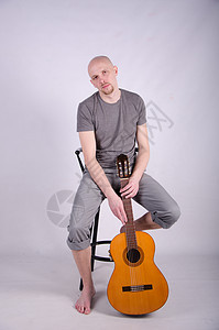 拿着吉他光秃秃的好人吉他手演员星星男人男性头发音乐会牛仔裤乐趣岩石图片
