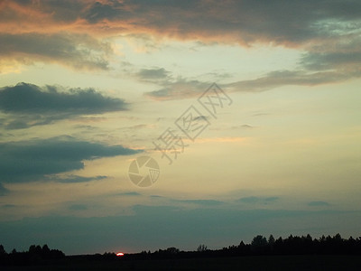 日落在森林上太阳草原天空红云阳光农田背景图片