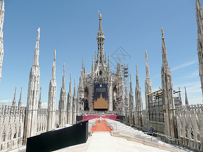 Madonnina 雕像在意大利米兰大教堂顶端石头地标雕塑大理石艺术大教堂太阳纪念碑金子蓝色图片
