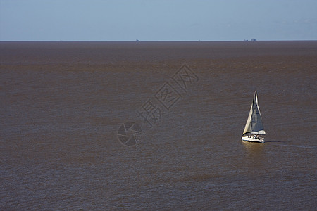 在普拉塔河中棕色灰色海浪蓝色航海海岸线太阳航行红色黑色图片